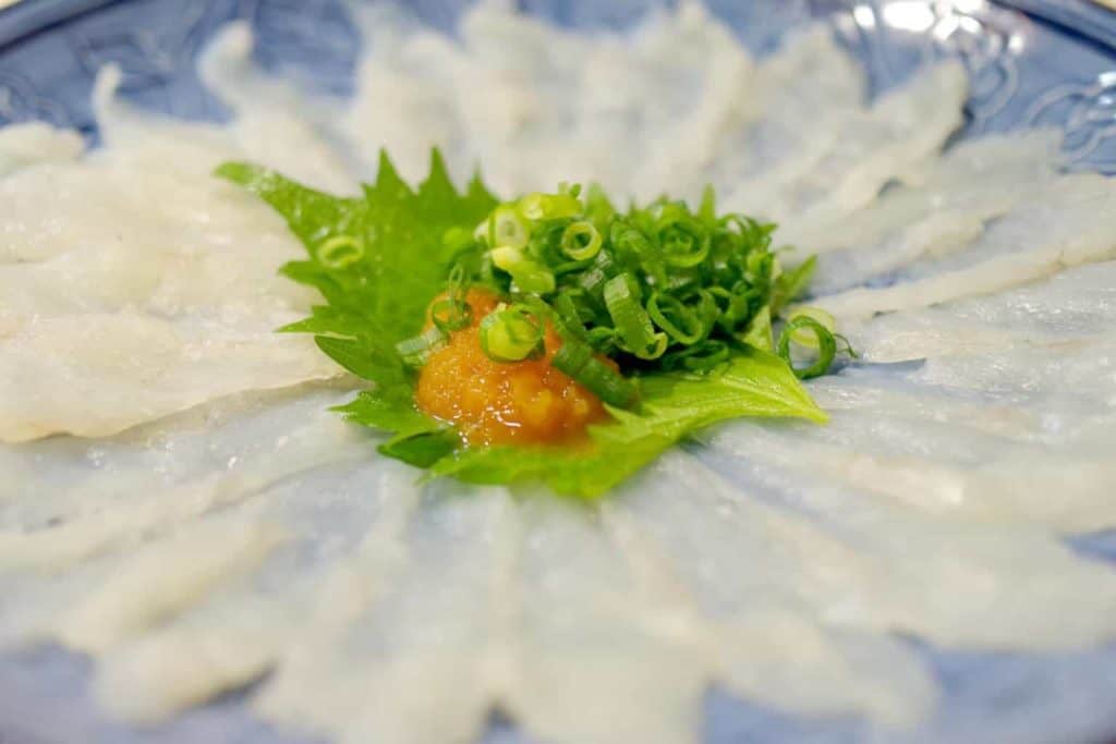 osaka one day itinerary - thinly sliced fugu meat topped with oba, roe, and chopped spring onion