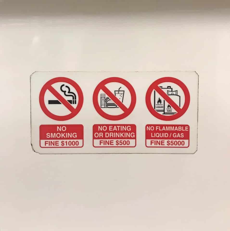 5 days singapore itinerary - no smoking, no eating or drinking sign, and no flammable liquid or gas sign on a MRT in Singapore