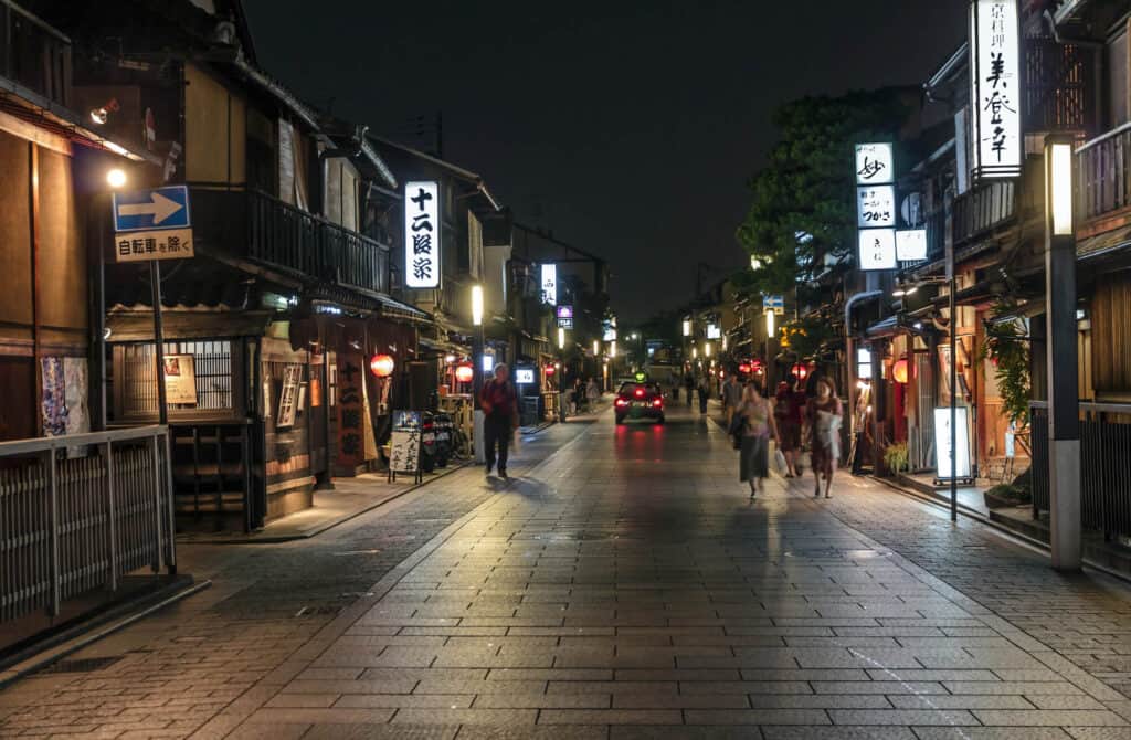 kyoto night attractions - people are walking along the Hanamikoji Street of Gion at night. 