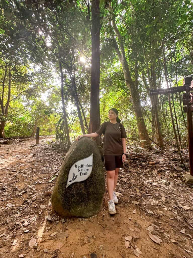 what to wear for hiking in Singapore - Me posing with the Macritchie Nature Trail rock sign