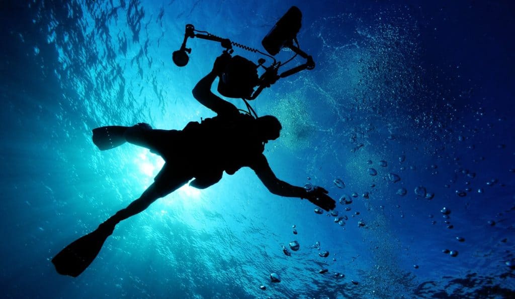 best caption for scuba diving - a picture of a diver holding his equipment while diving in the sea