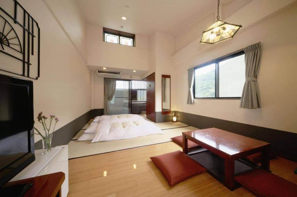 hakone private onsen for couples - a spacious room with 2 futon beds, seating area, and an indoor private onsen at  Ichinoyu Shinkan