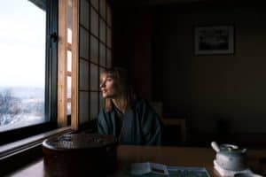 onsen ryokan kanazawa - a lady overlooking the window in a traditional ryokan room