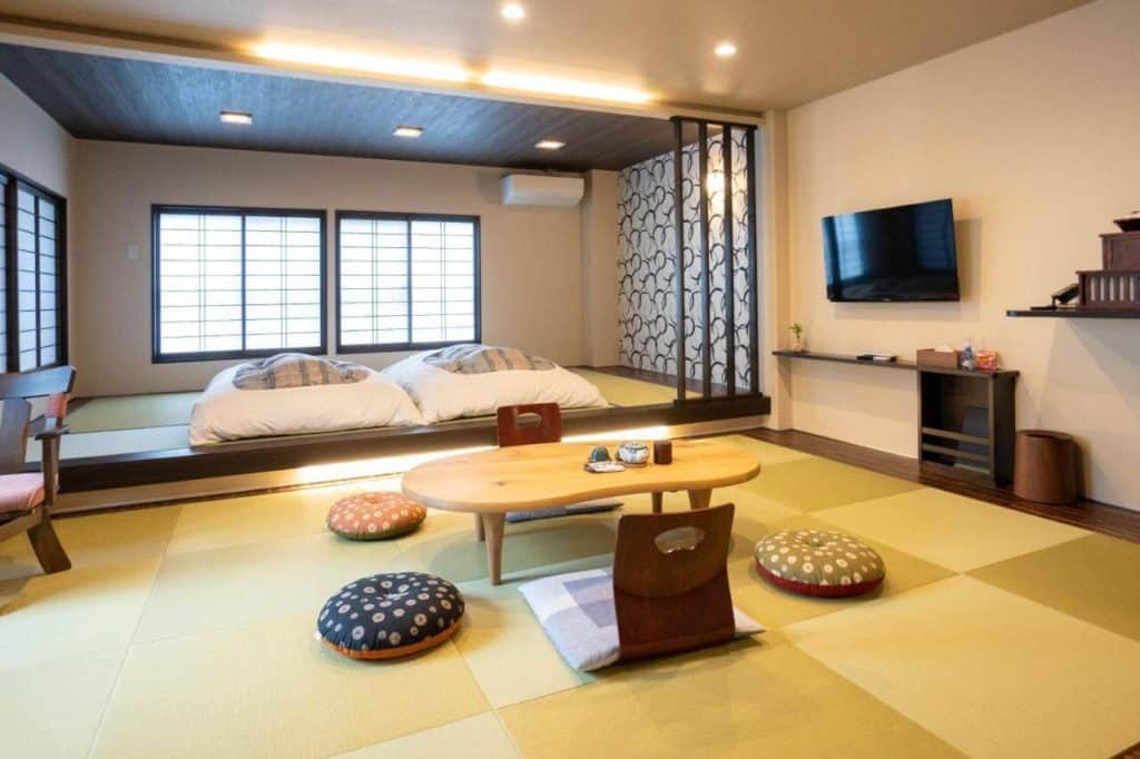 best ryokans in takayama - a room with 2 futon beds and a seating area equipped with a TV in Oyado Eitaro