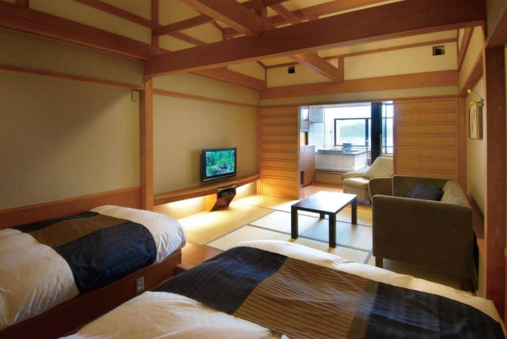takayama ryokan with onsen -  a room with two western beds, TV, table and an outdoor private onsen in Hoshokaku