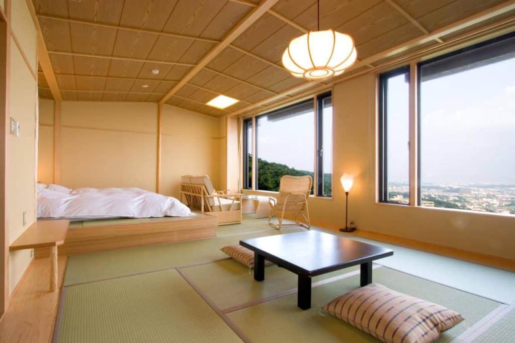 private onsen osaka - futon beds placed next to the seating area with opened windows at Sanso Kazenomori