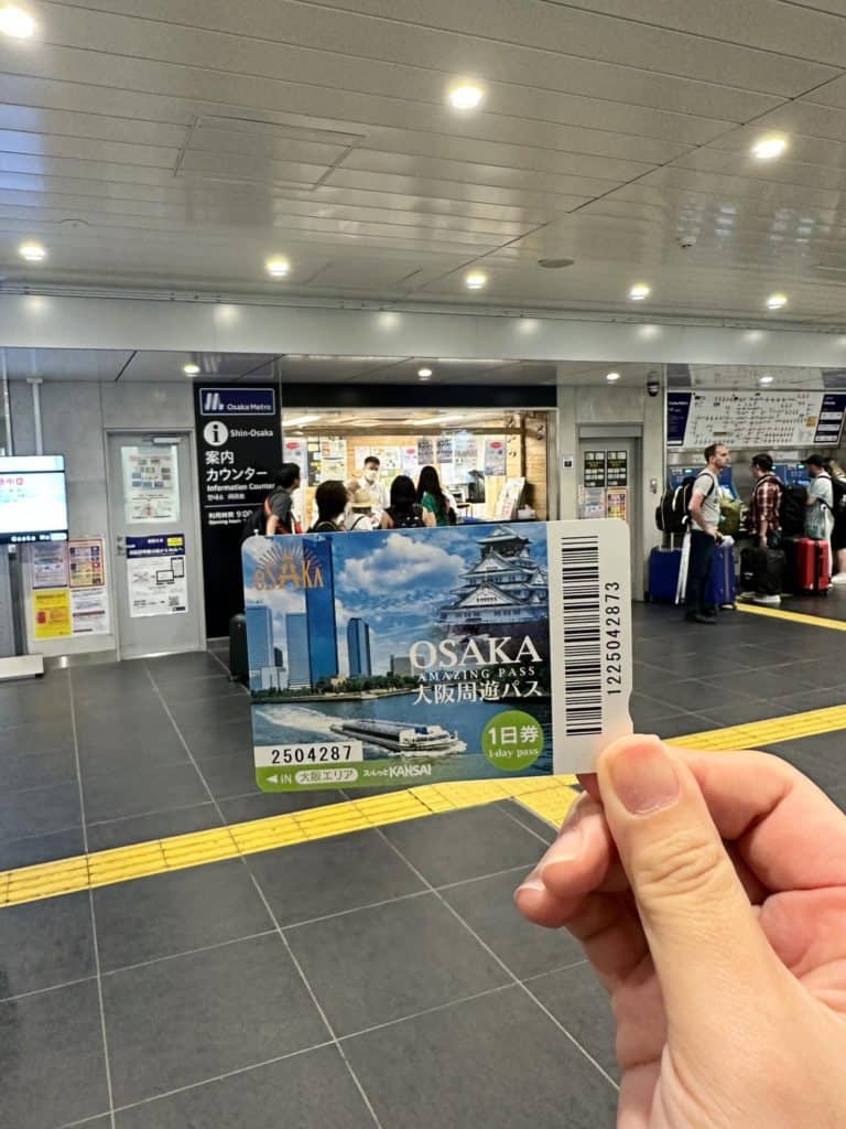 is osaka safe - me holding the 1-Day Amazing Osaka Pass taken in front of the redemption counter in Osaka Metro 