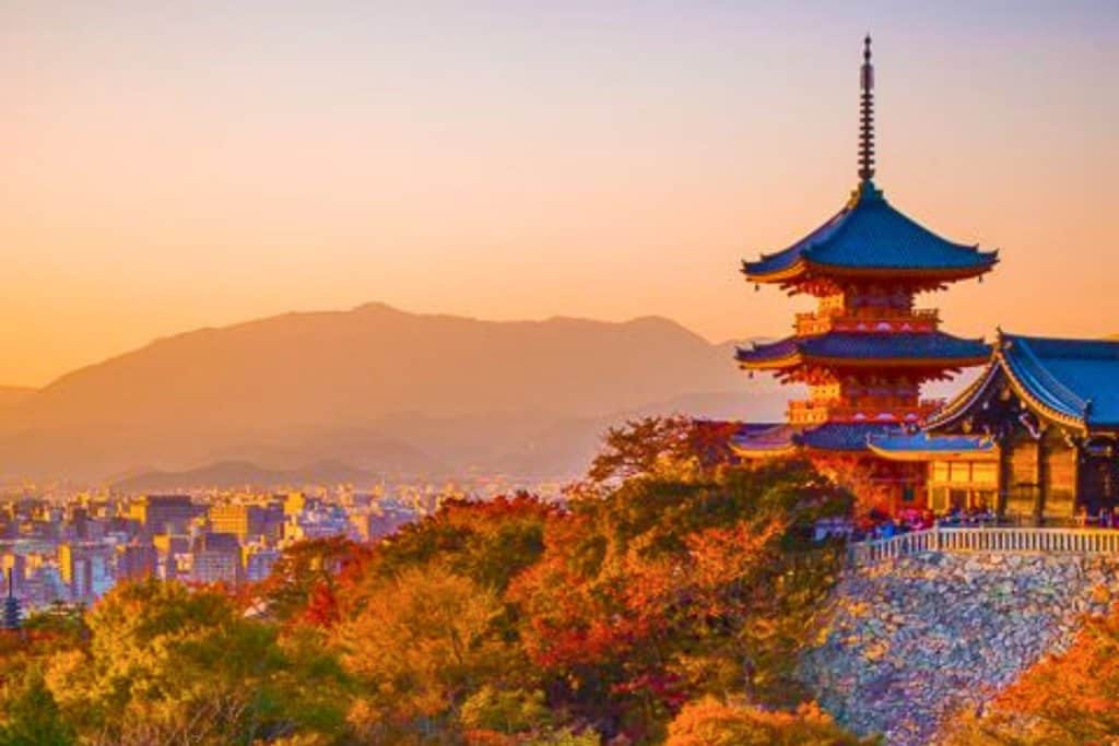 Fall Kyoto 3-day Itinerary - the pagoda of Kiyomizudera Temple surrounded by the fiery autumn foliage with huge mountain as the backdrop