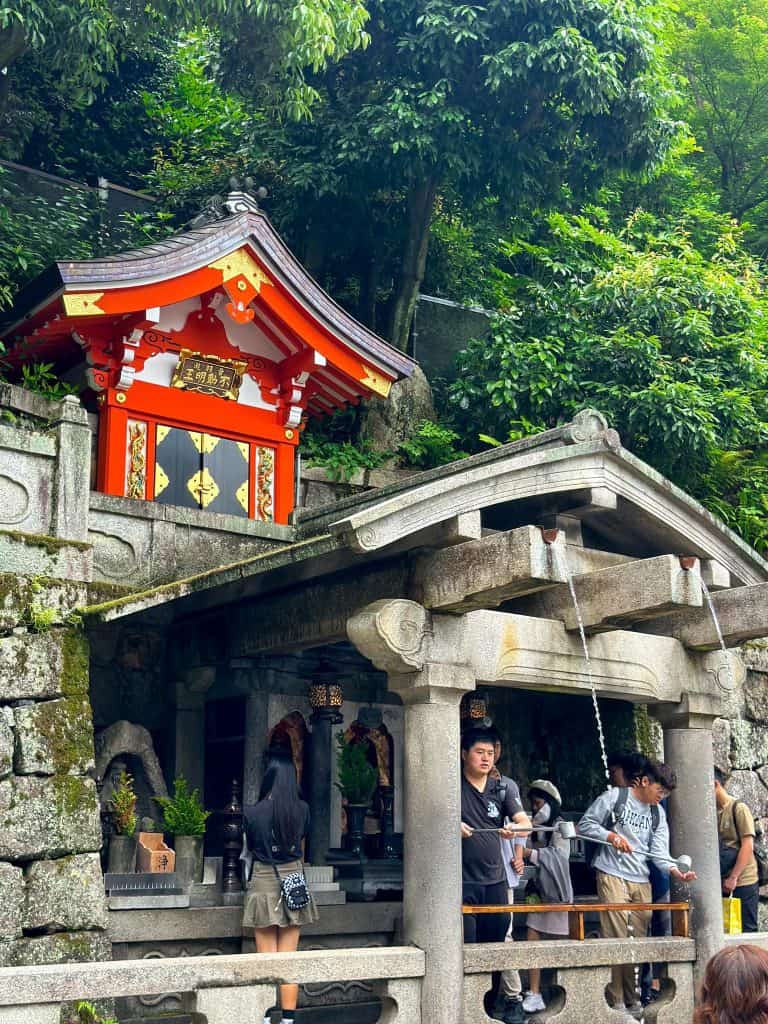 Kyoto fall itinerary - visitors queuing at Otowa Waterfall and perform the ritual