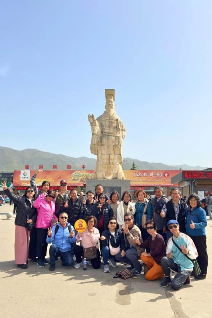 a group of tourist posing in front of Xi'an Mausoleum of Qin Shi Huang