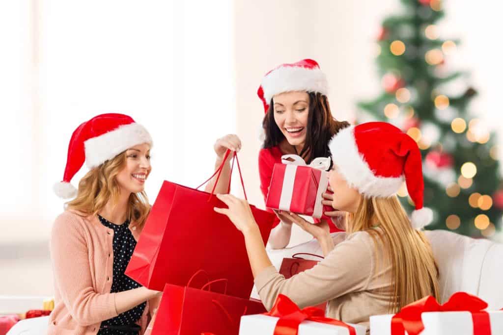 best Japanese-themed Christmas gift ideas - 3 ladies exchanging gifts wrapped in red during Christmas